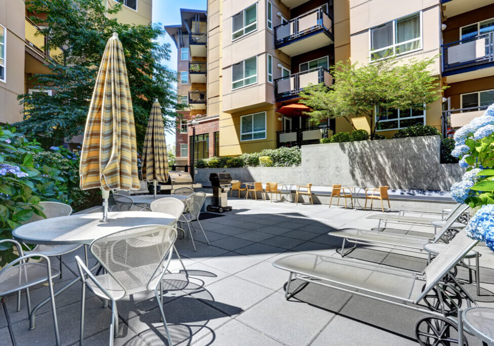 A modern loft courtyard with tables and chairs, barbecue area. New apartment house. Northwest, USA