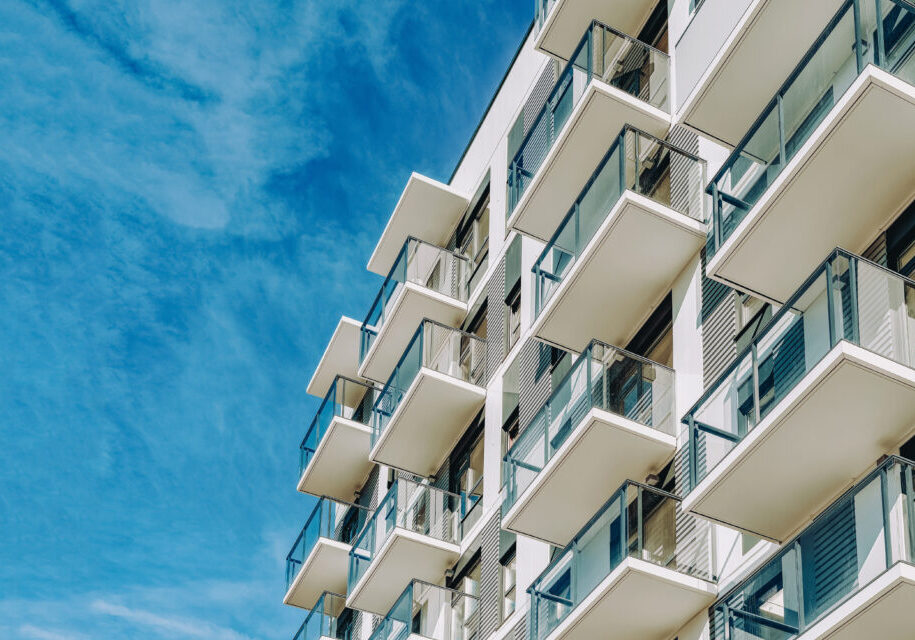 Detail of Modern residential apartment flat building exterior. Fragment of New luxury house and home complex. Part of City Real estate property and condo architecture. Copy space. Blue sky